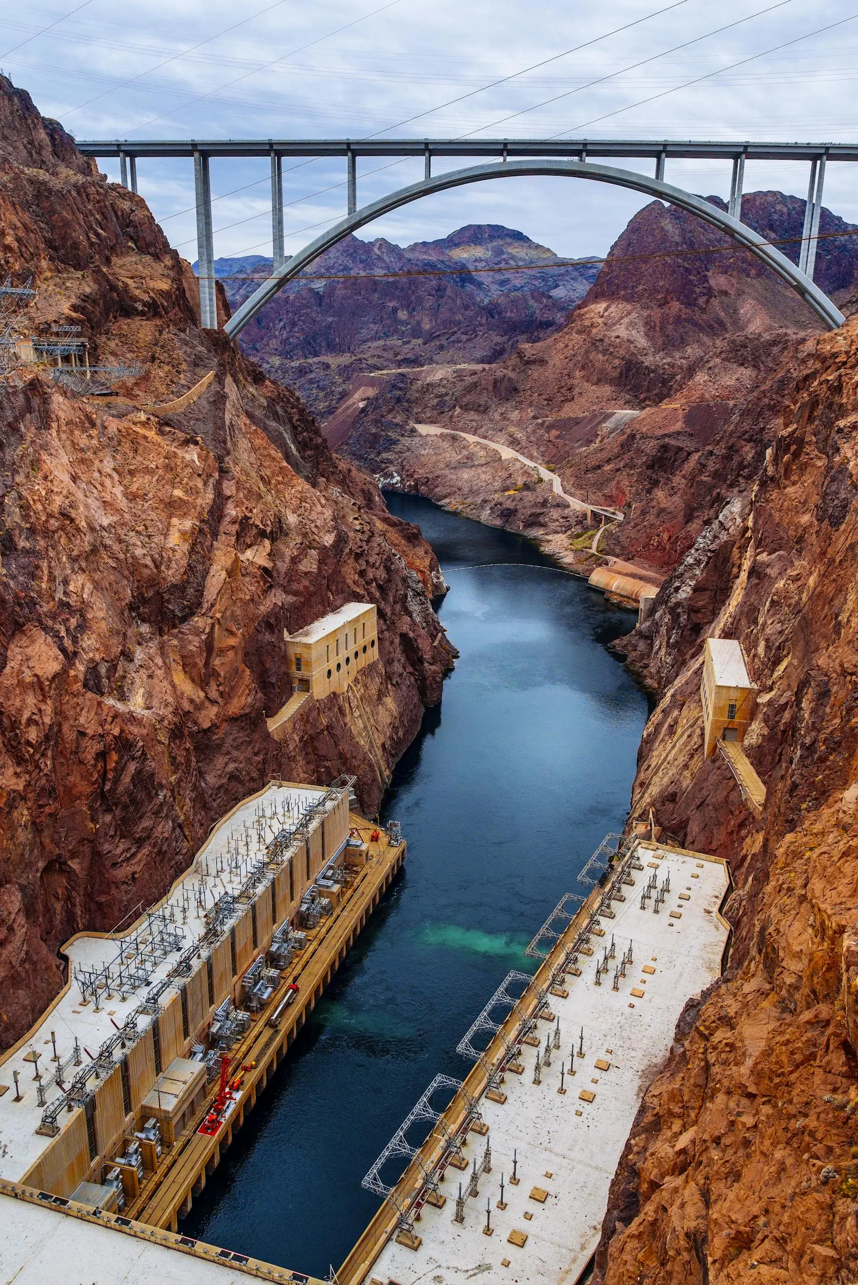 A picturesque landscape of the Hoover Dam with the Mike O'Callaghan–Pat Tillman Memorial Bridge looming overhead.